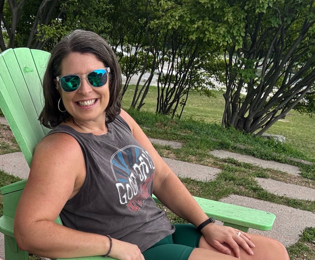 A. Sebesta smiling outdoors in a green chair